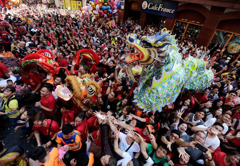 Dancers perform a dragon dance next to revellers in Manila, Philippines. EPA