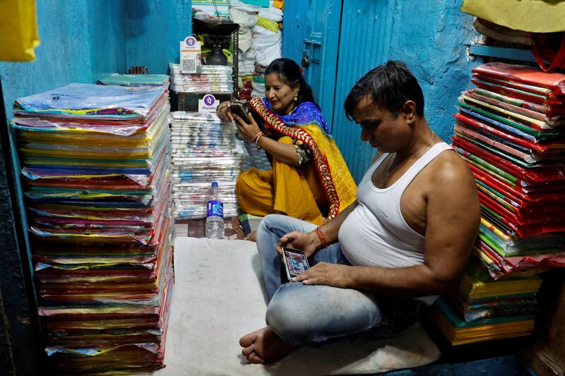 Kolkata shopkeepers watch election results on their mobile phones inside their shop. Reuters