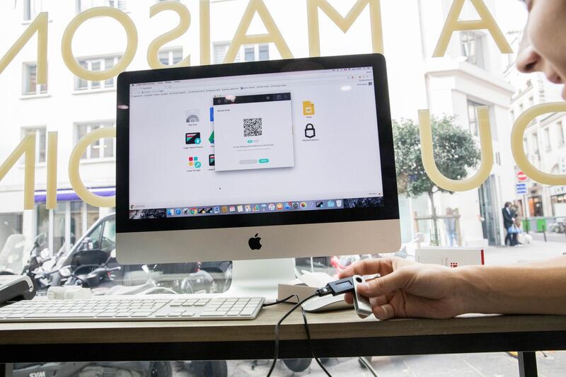 An employee holds a ledger wallet smartcard device as a Quick Response (QR) code is displayed on a Apple Inc. computer monitor during an ethereum currency transaction inside the offices of La Maison du Bitcoin bank in Paris, France, on Thursday, Nov. 23, 2017. Zimbabwe, where the price of bitcoin spiked to double the international rate after last week's military takeover, shows cryptocurrency skeptics where the real-world use of bitcoin, and possibly its future, lies. Photographer: Christophe Morin/Bloomberg