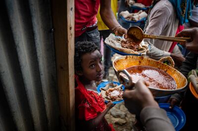 Elena, 7, centre, lines up with other displaced Tigrayans to receive food at a centre for the internally displaced in Mekele, in the Tigray region of northern Ethiopia. Ben Curtis / AP Photo