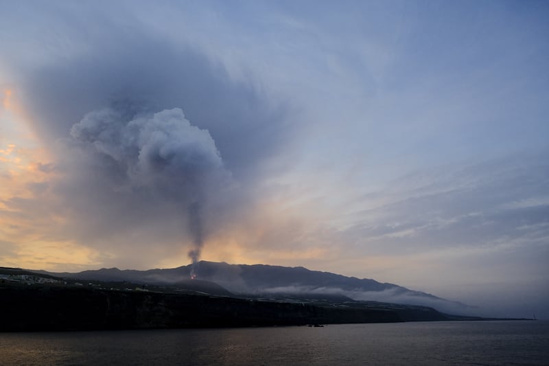 Smoke rises from the erupting Cumbre Vieja volcano as seen from the village of Tazacorte on La Palma. Photo: EPA