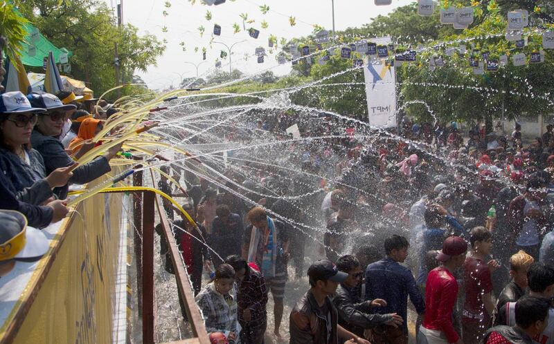 People are sprayed with water from the stage during the second day celebration of Myanmar New Year water festival in Mandalay, central Myanma. Thein Zaw / AP Photo