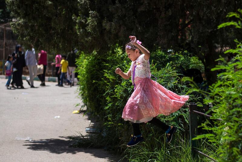 A girl  jumps as she celebrates Eid with her family at a zoo in Giza, Egypt. EPA