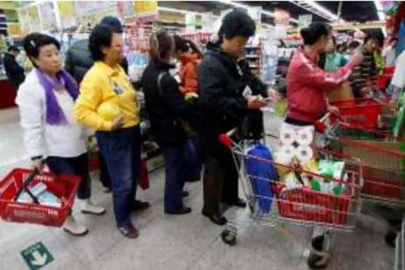 Shoppers line up at a supermarket checkout in Beijing Monday Nov. 24, 2008. Consumer prices rose by 4 percent in October from a year earlier following a marathon government effort to cool sharp rises in politically-sensitive food prices. That was down from September's 4.3 percent rate and a sharp decline from February's 12-year high of 8.7 percent.  (AP Photo/Greg Baker) *** Local Caption ***  XGB103_China_Economy.jpg