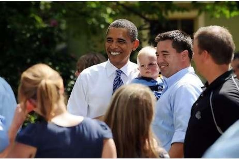 US President Barack Obama poses with residents after holding a discussion on the economy with local families at the Weithman family home in Columbus, Ohio