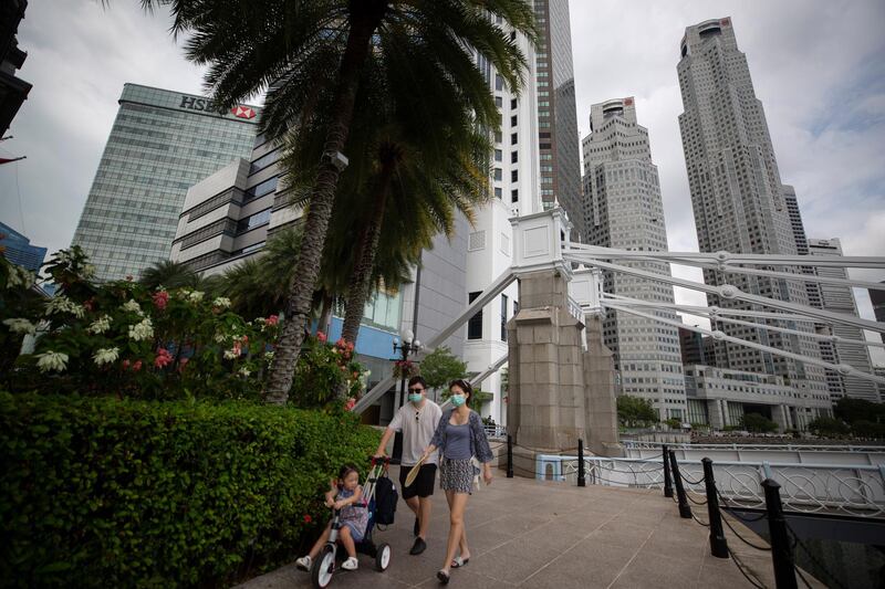 epa08390654 A couple wearing protective face masks pushe their child in a stroller as they walk through the Central Business District (CBD) during a partial lockdown 'circuit breaker' period to prevent the spread COVID-19 in Singapore, 29 April 2020. Singaporeâ€™s  economy may contract more than forecast this year entering a recession due to the coronavirus pandemic, according to the Monetary Authority of Singapore (MAS) on 28 April 2020. Gross domestic product (GDP) is expected to decline by one per cent to four percent due to the loss of economic activity in the country and globally.  EPA/HOW HWEE YOUNG