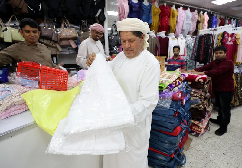 Abu Dhabi, United Arab Emirates - July 30, 2019: Mohammed Barakat 45, from Egypt shows us a Ihram which is worn on Hajj at Salmin Trading Shops. Monday the 30th of July 2019. Downtown, Abu Dhabi. Chris Whiteoak / The National