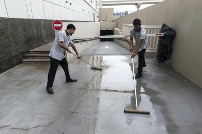 DUBAI, UNITED ARAB EMIRATES. 17 FEBRUARY 2019. Early morning rain in some parts of Dubai left substantial water puddles on the roads and sidewalks. Hotel staff clean up some standing water. (Photo: Antonie Robertson/The National) Journalist: None. Section: National.