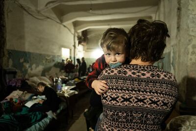 A woman holds a child in an improvised bomb shelter in Mariupol. AP Photo