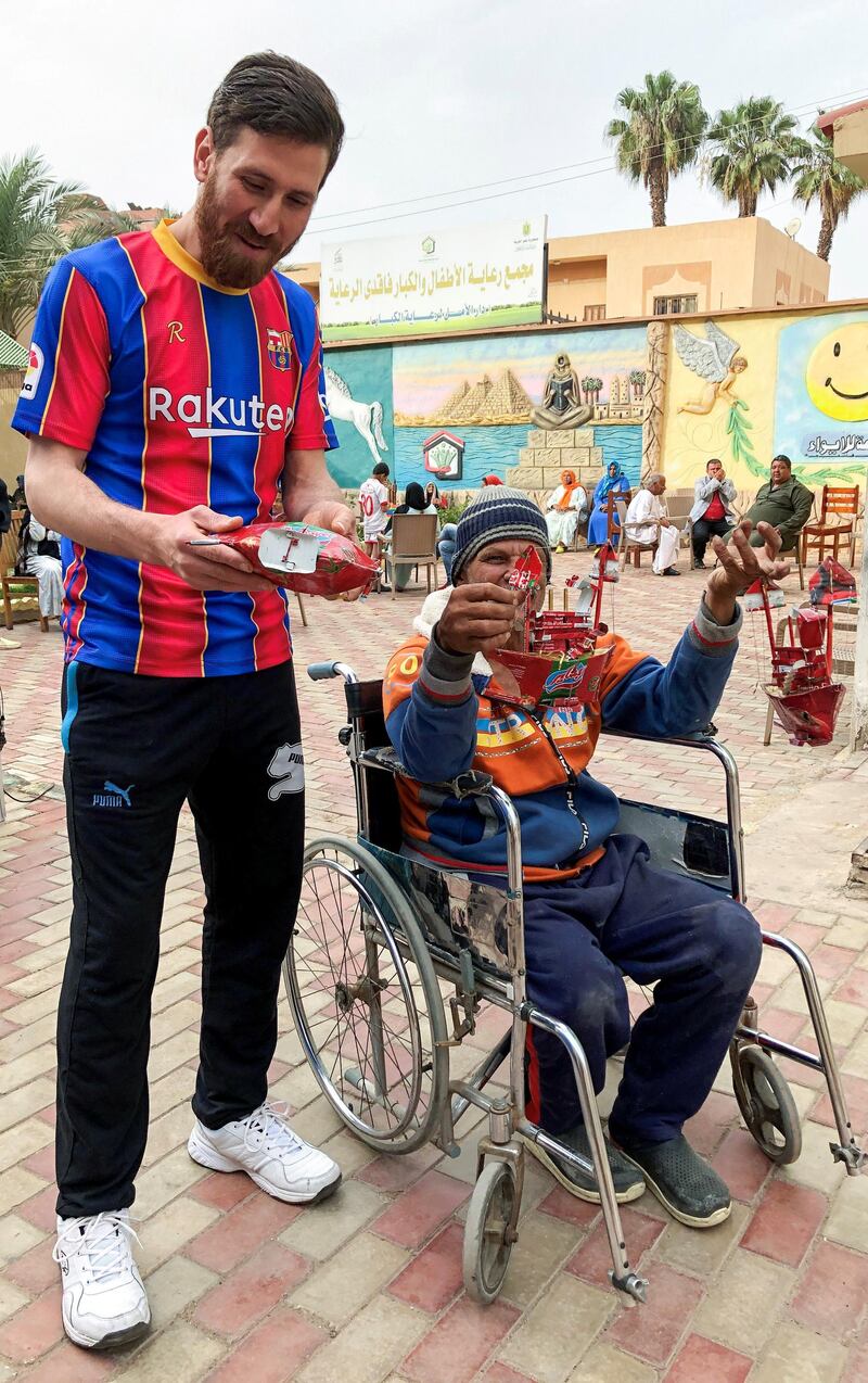 Islam Battah, wearing a Barcelona shirt, poses for a photo with a fan at a club training facility in the Nile Delta city of Zagazig. Reuters