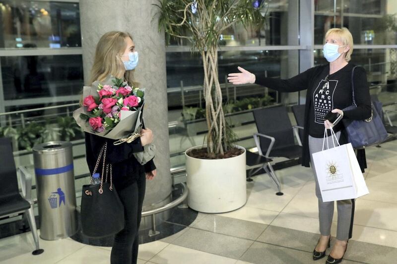 She meets her mother Christina at the airport - and remembers to keep her distance after an international flight
