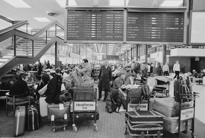 Passengers wait beneath a Heathrow departures board in January 1979. Getty