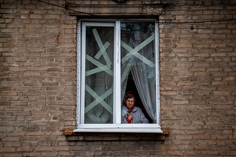 A resident behind a broken window at her home in Chasiv Yar, eastern Ukraine. AFP