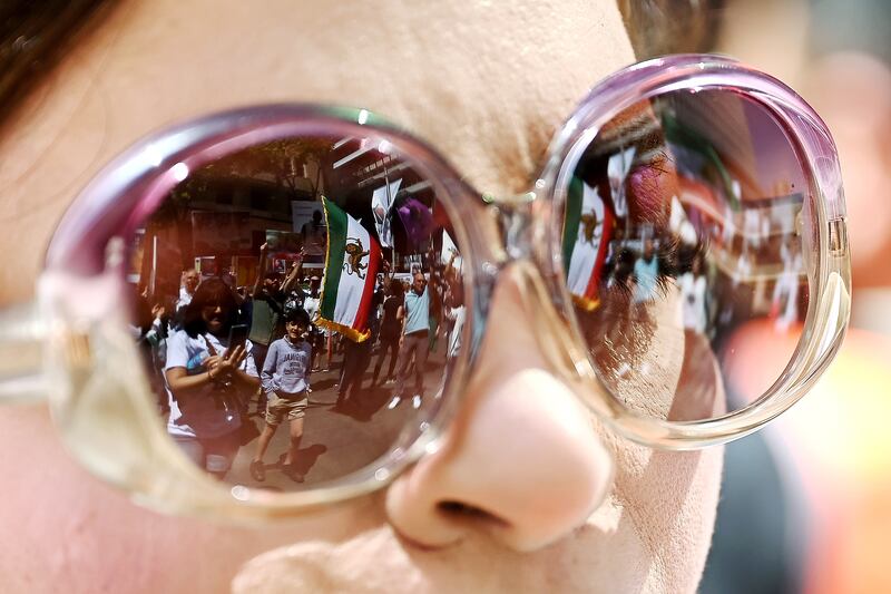 Protesters taking part in a 'Woman, Life, Freedom' rally for Iranian women, in Sydney,  Australia, are reflected in a pair of sunglasses. EPA