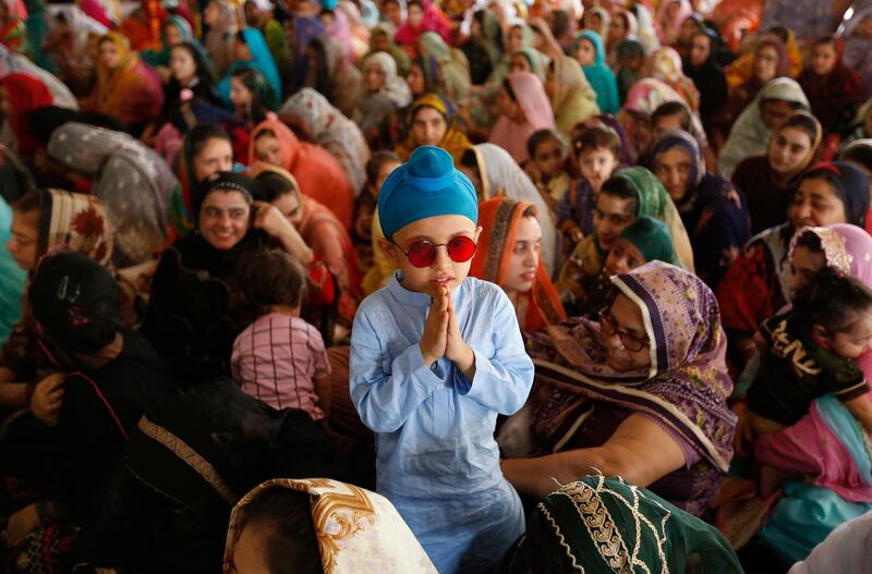 A Sikh child with his mother at a ceremony to observe the Martyrdom Day of Guru Arjan Dev Ji, at Gurudwara Dera Sahib, in Lahore, Pakistan. Hundreds of Sikh pilgrims are attending the 415th anniversary of the death of the fifth Sikh guru. AP Photo