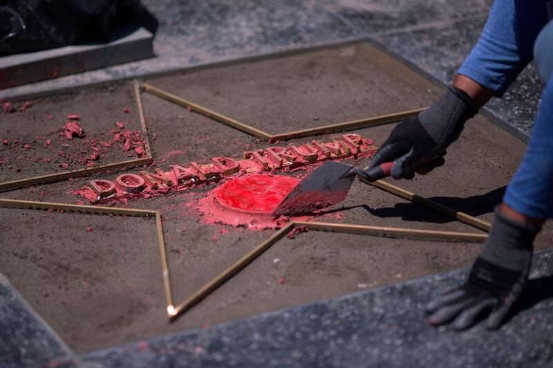 (FILES) In this file photo taken on July 25, 2018, workers replace the Star of US President Donald Trump on the Hollywood Walk of Fame after it was destroyed by a vandal.
The city council of West Hollywood has asked that the Star on  the Hollywood Walk of Fame for Donald Trump be removed, in part because of the way he treats women. The initiative by comes less than two weeks after the star was vandalized by a man with a pickax.
 / AFP PHOTO / DAVID MCNEW