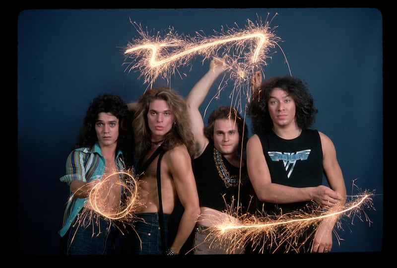 (Original Caption) : Picture shows the four members of the band Van Halen posing together in a studio. They are standing next to each other in front of a blue background waving sparklers in the air.   (Photo by Lynn Goldsmith/Corbis/VCG via Getty Images)
