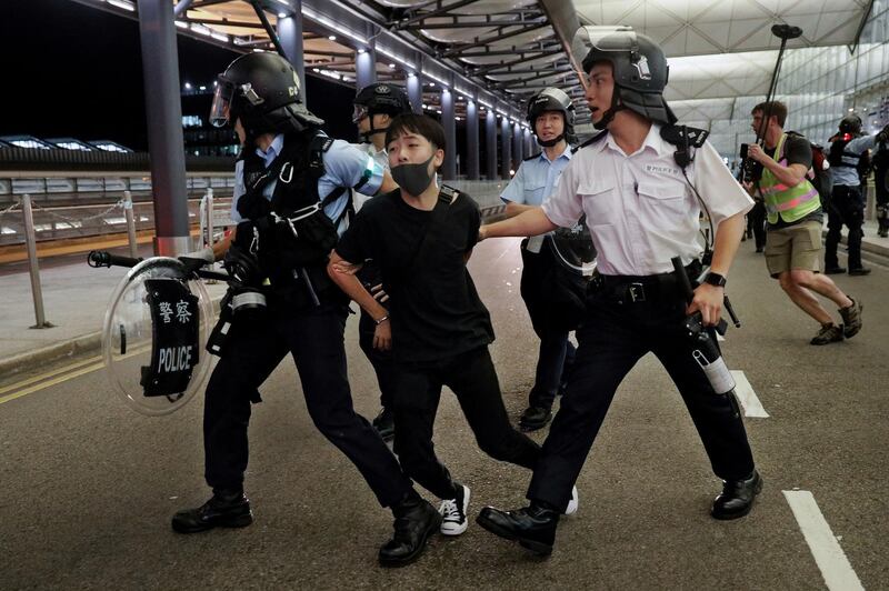 Policemen arrest a protester during a clash at the airport in Hong Kong. AP Photo
