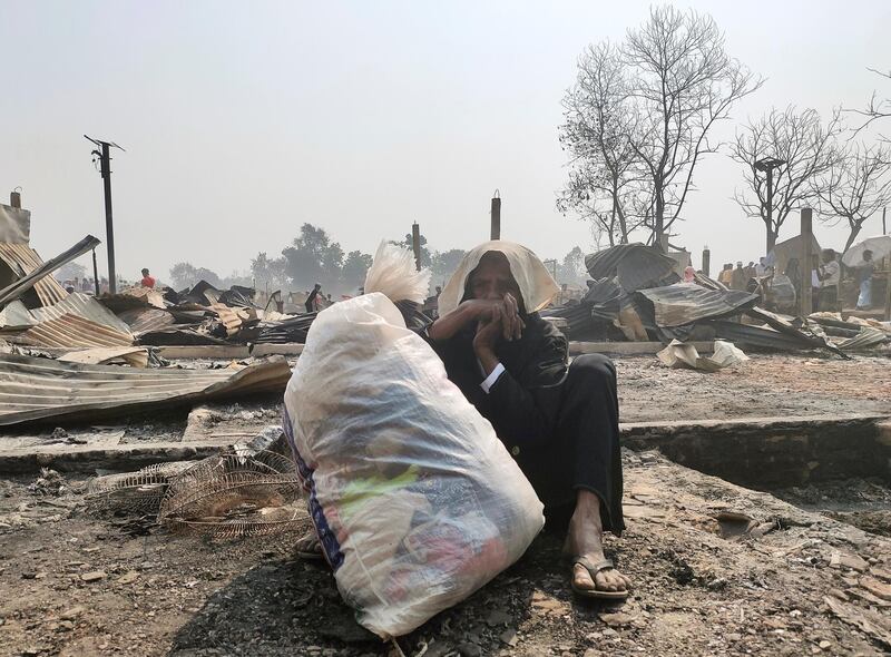 A Rohingya woman sits on the ground with her belongings as her shelter has been burned down following a fire that broke out at a Rohingya refugee camp in Cox's Bazar, Bangladesh. Reuters