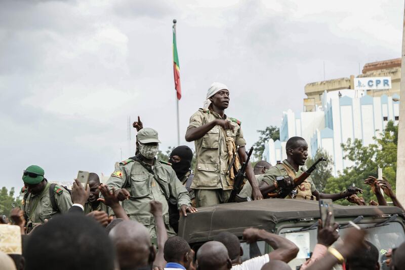 Crowds cheer as soldiers parade in vehicles along the Boulevard de l'Independance in Bamako, Mali. Getty Images