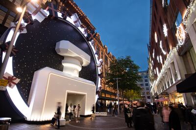 People walk by a seasonal Chanel display at Harrods in London. Getty Images