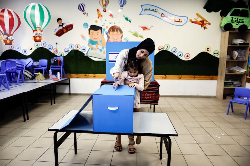 A little girl helps her mother cast her ballot on the day of Israel's general election at a polling station in Taibe, northern Israel. Reuters