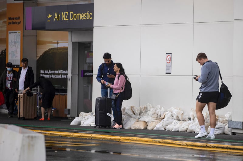 Stranded passengers wait outside Auckland Airport after flights were cancelled. AP