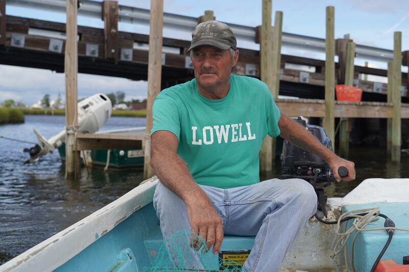 Mr Eskridge drives his small boat through shallow water as he heads to his crab shanty. 