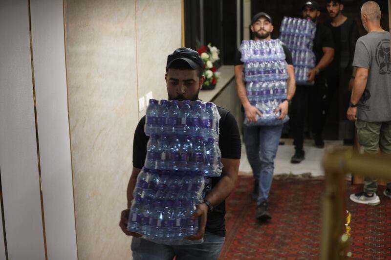 Palestinians carry water to help families who fled their homes  in Jenin, in the occupied West Bank. EPA