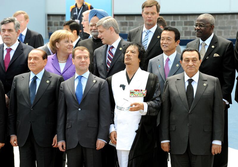 epa02610437 (FILE) A file photo dated  10 July 2009 shows Libyan leader Muammar Gaddafi in the center of international politicians, (L-R, first row) Italian Premier Silvio Berlusconi, Russian President Dmitry Medvedev and Egyptian President Hosni Mubarak, (L-R, second row) British Premier Gordon Brown, German Chancellor Angela Merkel, Canadian Premier Stephen Harper, Japanese Premier Taro Aso and FAD (International Fund for Agricultural Development) President Kanayo F. Nwanze and Dutch Premier Jan Peter Balkenende (rear, 2-R)  at the G8 Summit in L'Aquila, Italy. Born in 1942 in Sirte, then Italian Libya, into a Bedouin family, Gaddafi went to a military academy and joined an anti-monarchy conspiracy, which brought him into power by coup d'etat against King Idris on 01 September 1969. His 41-year rule as 'Leader of the Revolution' may now come to a violent end as uprisings have spread to Libya from neighbouring Tunisia and Egypt. While protesters are taking control of Libyan cities and the UN and many Western states imposed sanctions, 68-year-old Gaddafi is still fighting to maintain his grip on the country.  EPA/ETTORE FERRARI *** Local Caption *** 00000401790458 02610437.jpg