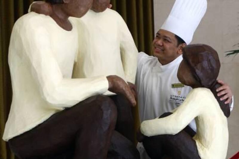 Dubai, United Arab Emirates- June 23,  2011:  Internationally Acclaimed & Award winning Carving Artist Chef Feliciano Baisas pose next to his  Life Size Chocolate Sculpture of Father & two children at the Shagri-La Hotel  in Dubai .  ( Satish Kumar / The National ) Story by Ramona 