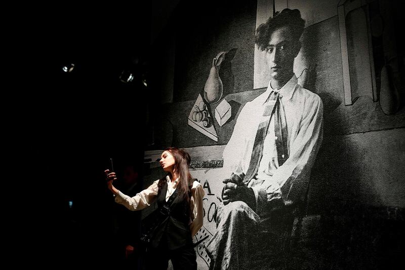 A woman poses in front of a large scale photograph of Spanish artist and surrealist icon Salvador Dali (1904 - 1989) during the exhibition "Salvador Dali - Magic Art" hosted at the Manege Central Exhibition Hall in Moscow on January 30, 2020. The exhibition features over 180 works by Dali and will be open to the public until March 25, 2020. - RESTRICTED TO EDITORIAL USE - MANDATORY MENTION OF THE ARTIST UPON PUBLICATION - TO ILLUSTRATE THE EVENT AS SPECIFIED IN THE CAPTION
 / AFP / Alexander NEMENOV / RESTRICTED TO EDITORIAL USE - MANDATORY MENTION OF THE ARTIST UPON PUBLICATION - TO ILLUSTRATE THE EVENT AS SPECIFIED IN THE CAPTION
