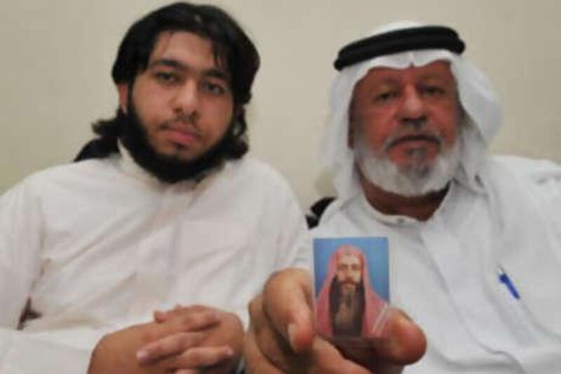 A picture of Abdulraheem al Murbati is held by his brother, Abdullah. The prisoner's son Osama looks on.