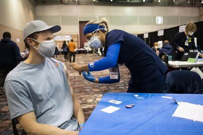A person with a blue wristband and seated at a table with a blue tablecloth receives a dose of the Johnson & Johnson Janssen Covid-19 vaccine at the Atlantic County vaccination megasite in Atlantic City, New Jersey, U.S., on Thursday, April 8, 2021. New Jersey, where hospitalizations and deaths from Covid-19 have been rising, has some of the highest rates of the more-contagious B.1.1.7 strain, adding to the pressure on officials. It has vaccinated about 43% of its residents, above the U.S. average but still leaving millions to go. Photographer: Mark Kauzlarich/Bloomberg