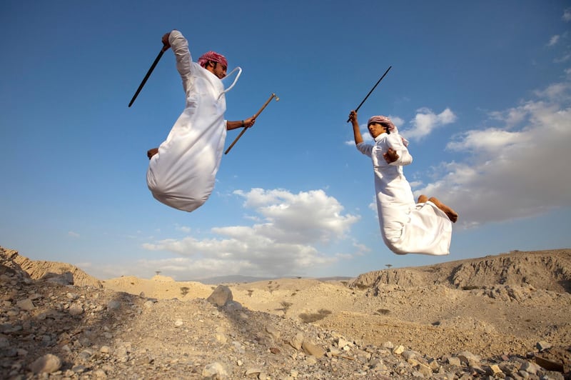UAE - Ras Al Khaimah - Dec 06 - 2011:  Brothers Mohammed Al Shehhi (L), 22, and Abdulla Al Shehhi, 16, perform the the The Mzafin (confontration) during the sword dance at Khatt town. ( Jaime Puebla - The National Newspaper )