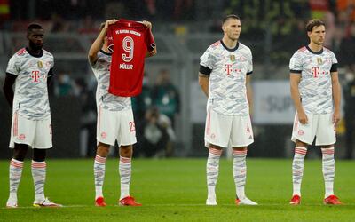 Bayern Munich's Thomas Muller holds the jersey of Gerd Muller as a tribute before the match against Dortmund. Reuters