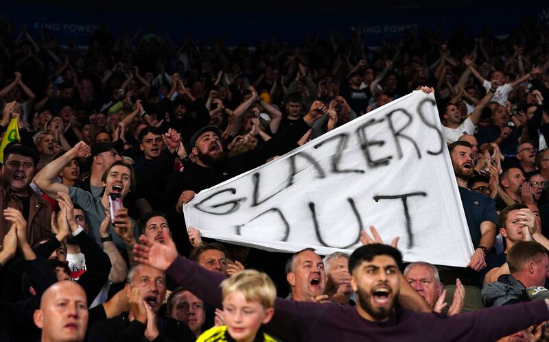 Manchester United fans in the stands with a Glazers Out banner. PA