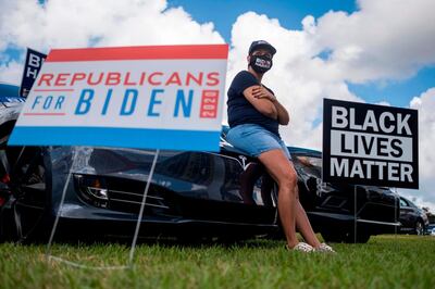TOPSHOT - A supporter listens as former US President Barack Obama speaks at a Biden-Harris drive-in rally in Orlando, Florida on October 27, 2020. / AFP / Ricardo ARDUENGO
