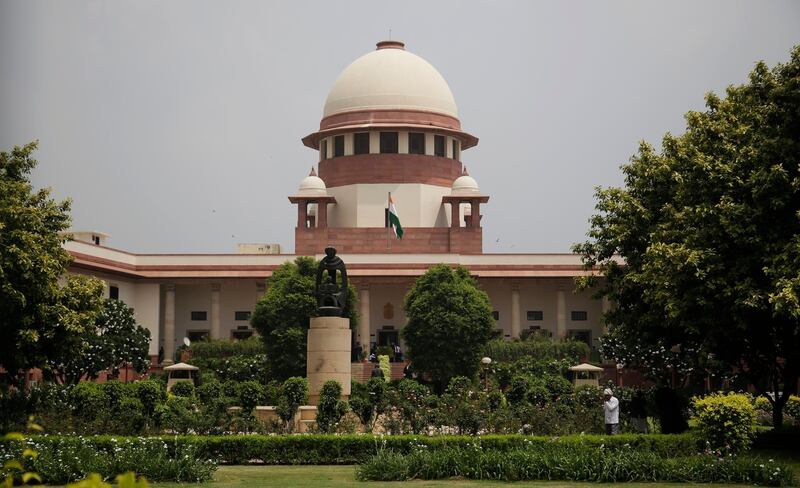 A gardener works in the lawns of the Supreme Court in New Delhi, India, Tuesday, Aug. 22, 2017. India's Supreme Court said Tuesday that the Muslim practice that allows men to instantly divorce their wives is unconstitutional and requested the government legislate an end to the practice. (AP Photo/Altaf Qadri)