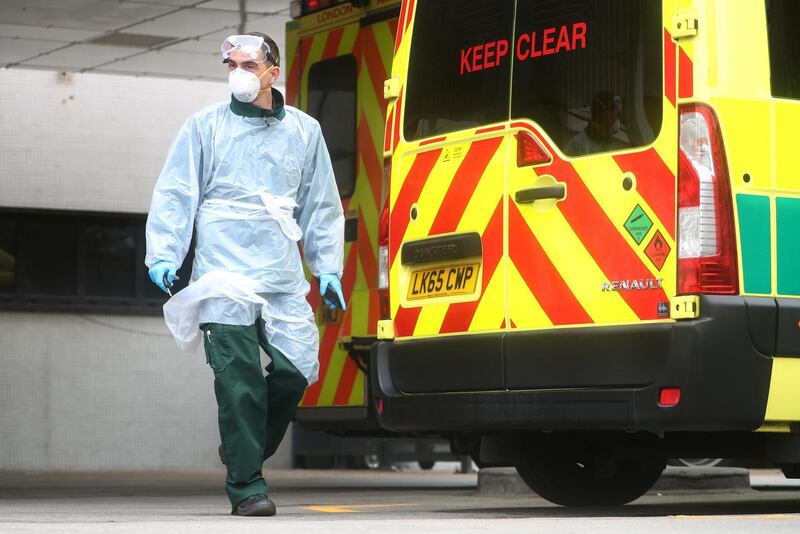  A paramedic wearing a protective face mask and gloves is seen at the back of an ambulance outside St Thomas' hospital, as the spread of the coronavirus disease (COVID-19) continues, London, Britain, April 1, 2020. REUTERS/Hannah McKay