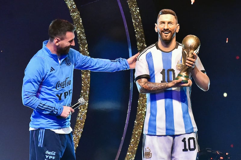 Argentina's Lionel Messi looks at a statue of himself during a tribute by Conmebol to the members of the Argentine national team for winning the Qatar 2022 World Cup. AFP