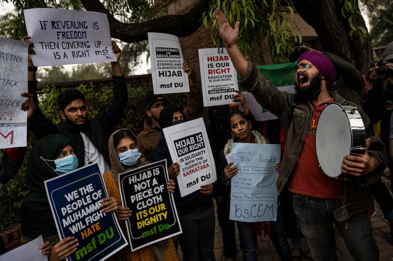 An Indian Sikh student joins Muslim girls in a protest against Karnataka's hijab ban, in New Delhi, India, this month. AP