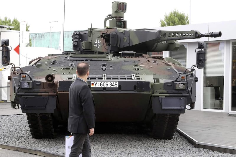 A man looks at a tank at the Eurosatory show. Jacques Demarthon/AFP