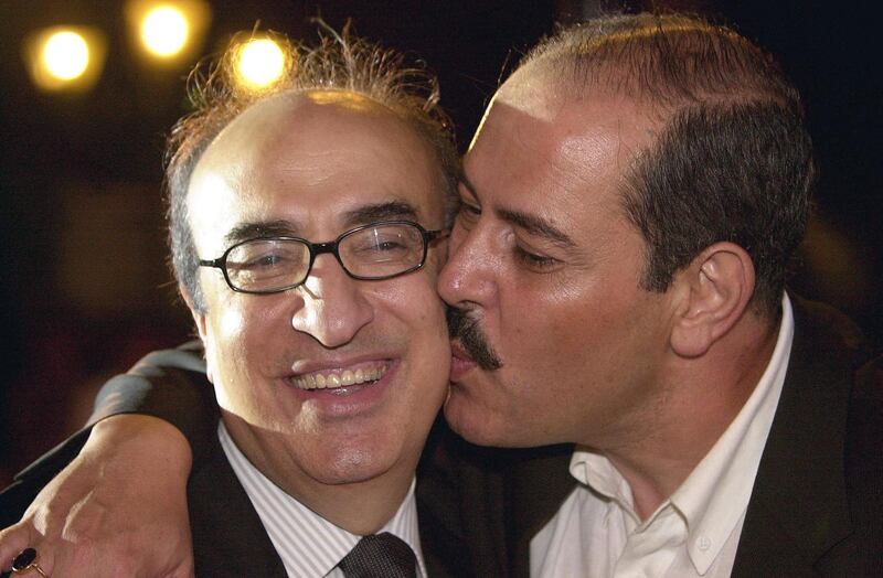 (FILES) In this file photo taken on June 25, 2003, Tunisian singer Lutfi Bushnak kisses late Lebanese musician Elias Rahbani (L) during the Alexandria International Music Festival in the Mediterranean Egyptian port city. Lebanese media reported the death of Elias Rahbani, one of the Arab world's leading pop musicians who is in his early 80s, after a long struggle with illness on January 4, 2021. / AFP / -

