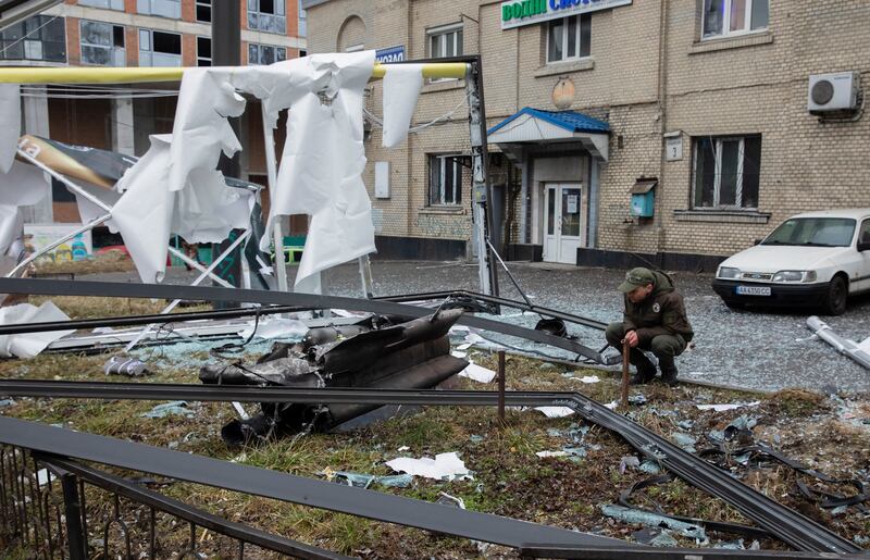 A man looks at the debris of an unidentified object in the aftermath of an explosion in Kiev. EPA