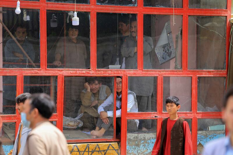 People look on from inside a building in the aftermath of multiple bomb blasts outside a school in a Shi'ite majority neighborhood in Kabul, Afghanistan. EPA