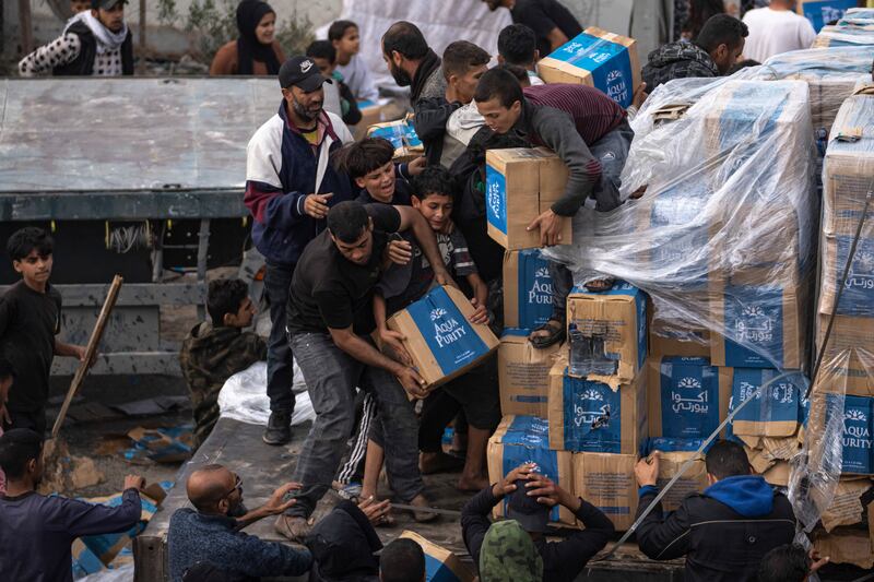 Palestinians take boxes from a humanitarian aid truck as it crossed into the Gaza Strip AP