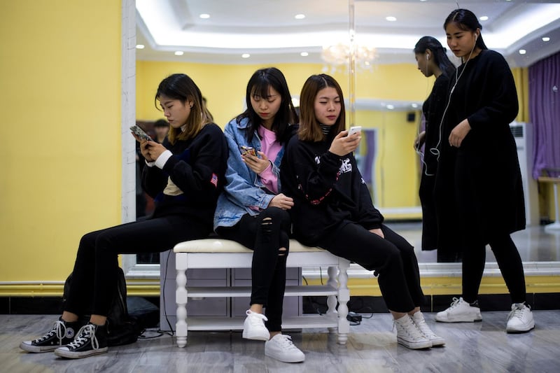 This picture taken on March 14, 2017 shows students looking at their smartphones during a class at the Yiwu Industrial & Commercial College in Yiwu, east China's Zhejiang Province. 
Hordes of Chinese millennials are speaking directly to the country's 700 million smartphone users, streaming their lives to lucrative effect, fronting brands and launching businesses. They are known as "wanghong" -- literally hot on the web -- and they now represent a multi-billion-dollar industry, becoming so big that it has its own university curriculum. At Yiwu Industrial & Commercial College, classrooms for the 34 mostly female students are typically dance studios, catwalks strafed by flashing lights, and bustling makeup rooms. 
 / AFP PHOTO / Johannes EISELE / TO GO WITH Lifestyle-celebrity-retail-China-internet, FEATURE by Albee ZHANG