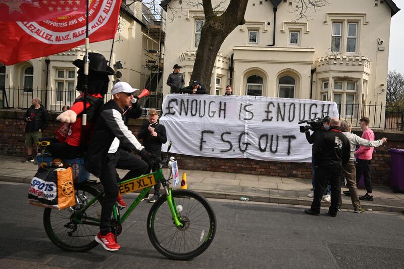 Supporters protest against Liverpool's US owners as the team bus arrives at Anfield. AFP