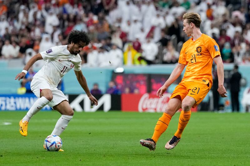 Qatar's Akram Afif and Frankie de Jong of the Netherlands challenge for the ball. AP 